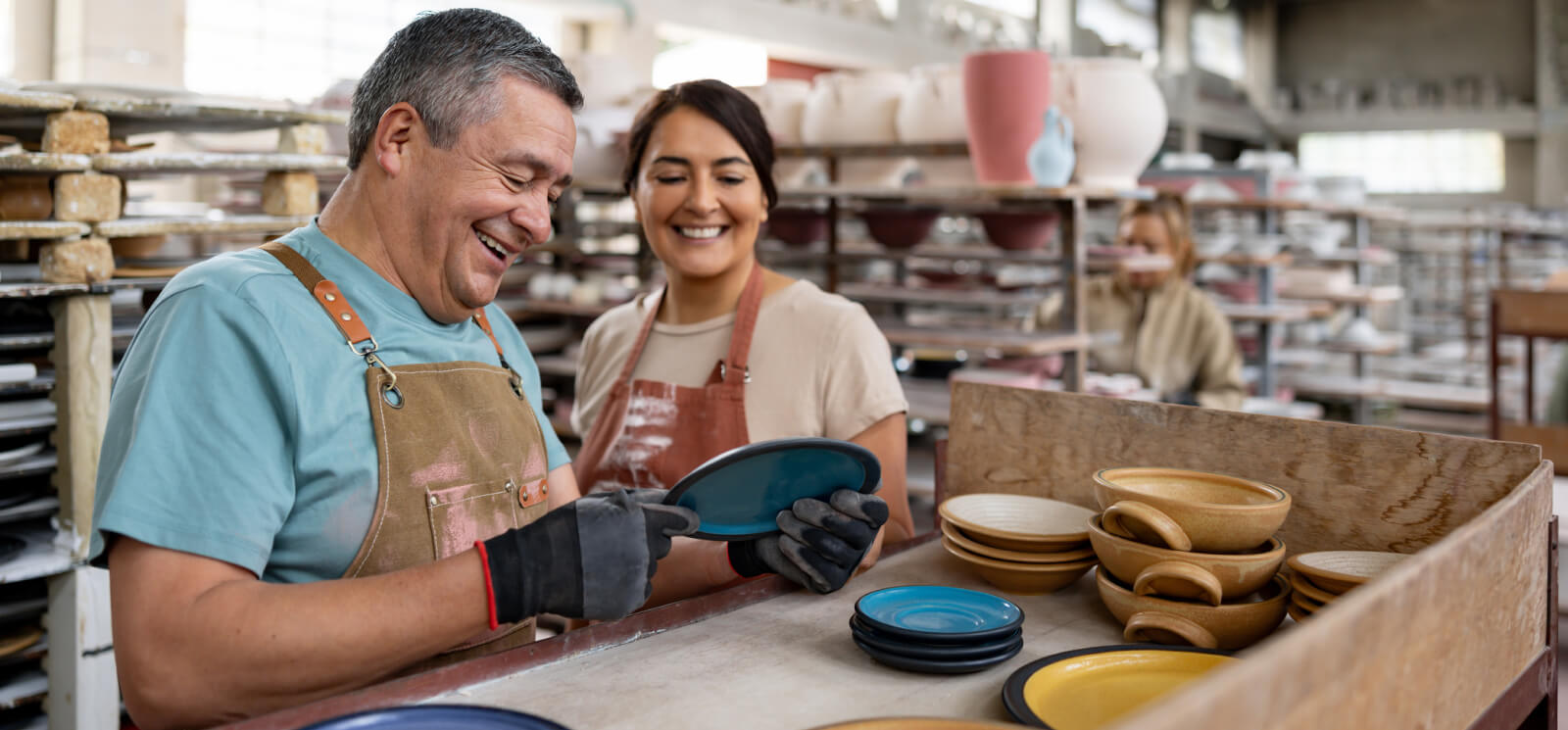 Two workers inspecting pottery inside a studio