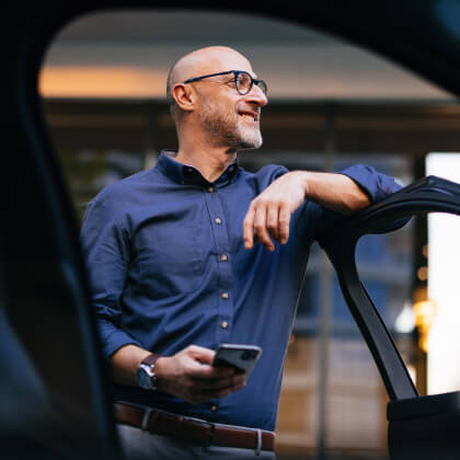 A man standing outside his car with the door open