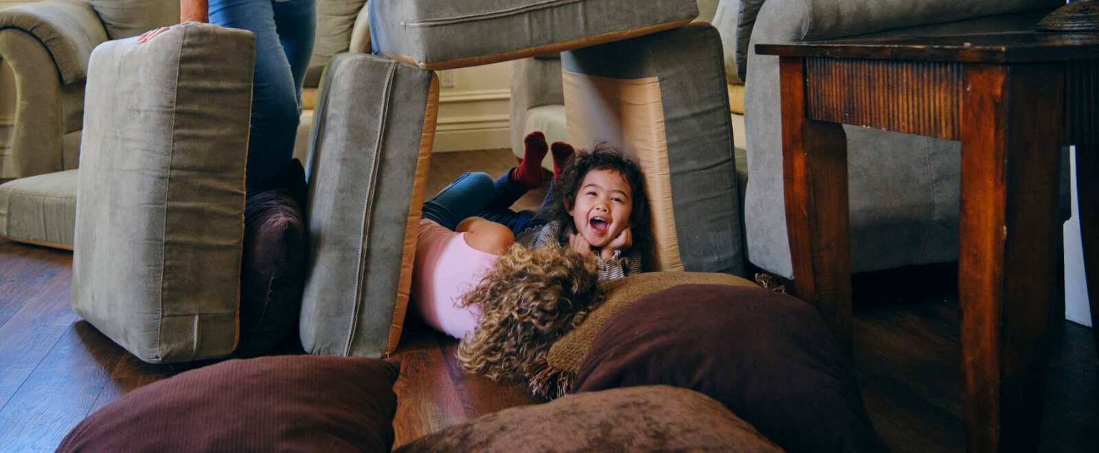 Two kids playing inside a pillow fort